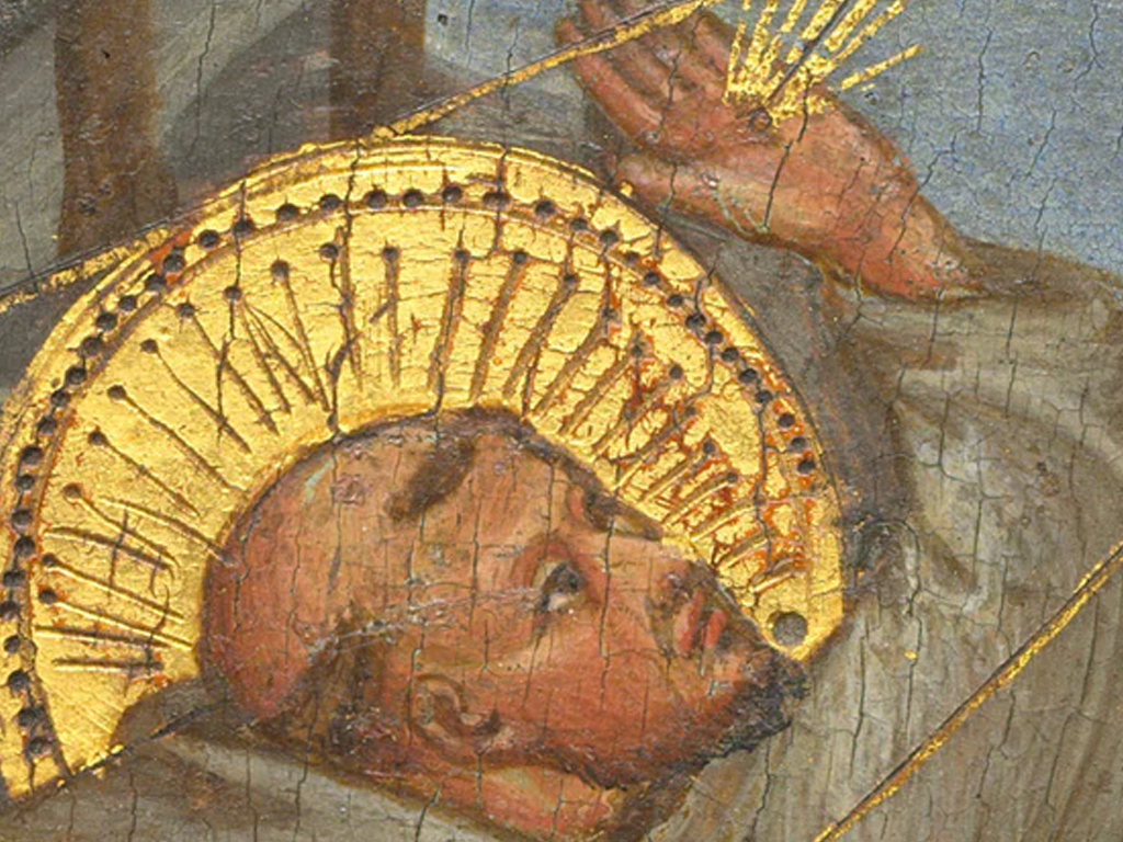 Close-up of a religious figure with a golden halo, showcasing intricate details and textures in the artwork.